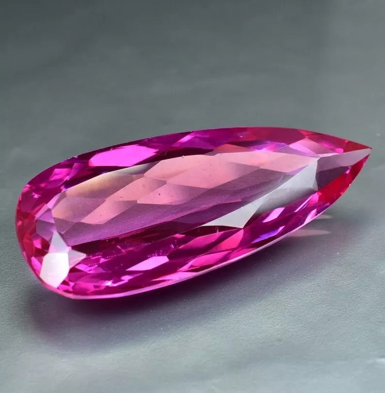 Royal Pink Ceylon Sapphire gemstone on a gray background
