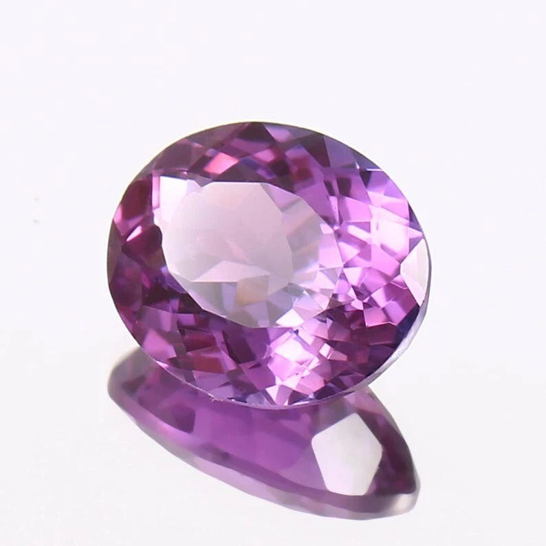 Purple Taaffeite gemstone on a white background