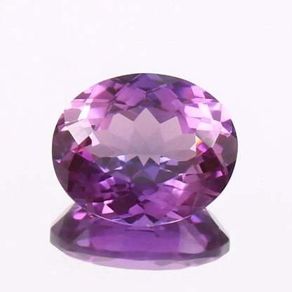 Purple Taaffeite gemstone on a white background