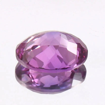 Faceted Taaffeite purple gemstone on a white background
