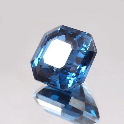 Faceted blue Tourmaline gemstone on a light gray background