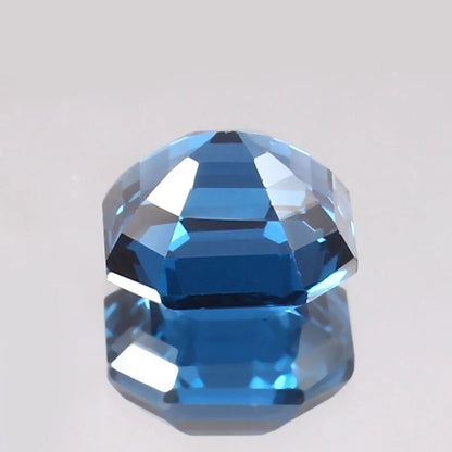 Faceted blue Tourmaline gemstone on a light gray background