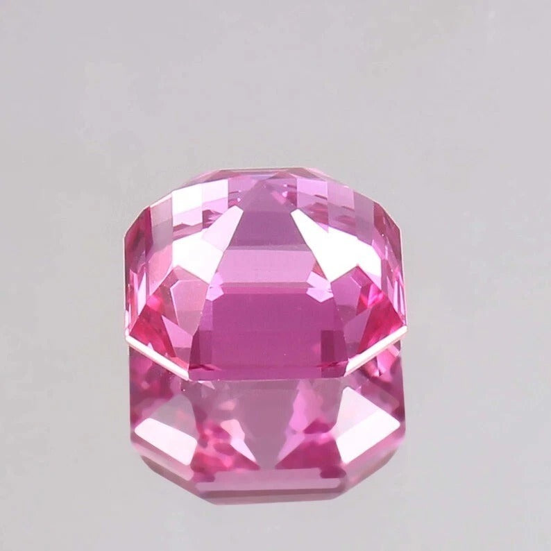 Faceted Flawless Ceylon Pink Sapphire gemstone on a light gray background