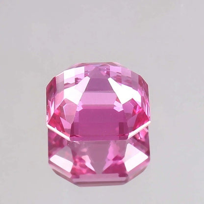 Faceted Flawless Ceylon Pink Sapphire gemstone on a light gray background