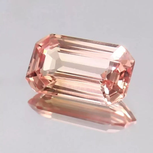 Peach Ceylon Padparadscha Sapphire gemstone on a light gray background
