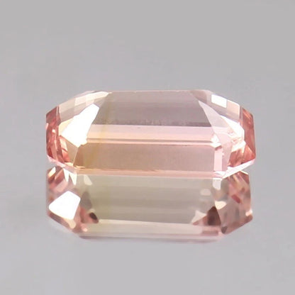 Peach Ceylon Padparadscha Sapphire gemstone on a gray background