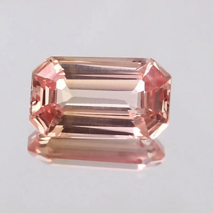 Peach Ceylon Padparadscha Sapphire gemstone on a light gray background