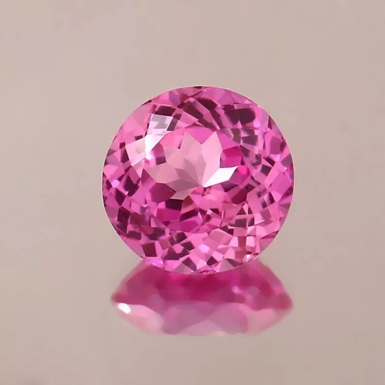 Ceylon Pink Sapphire gemstone on a beige background