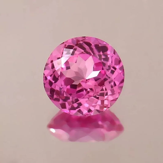 Ceylon Pink Sapphire gemstone on a beige background