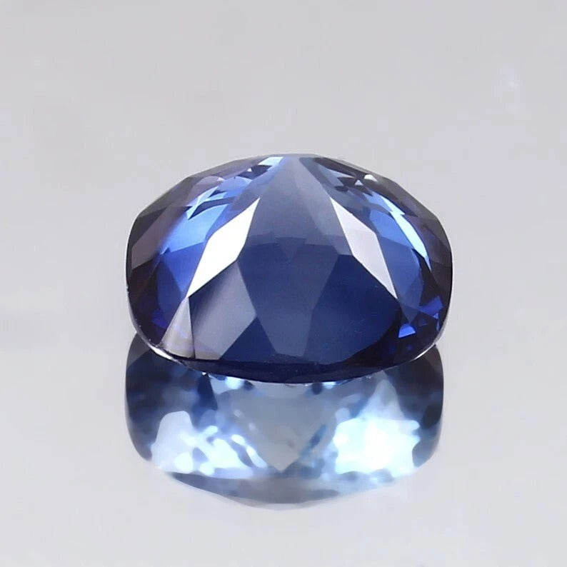 Faceted Blue Sapphire gemstone on a light gray background