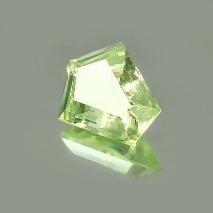 Chrysoberyl  green gemstone on a gray background