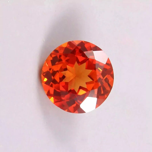 Round Orange Sapphire gemstone on a light gray background