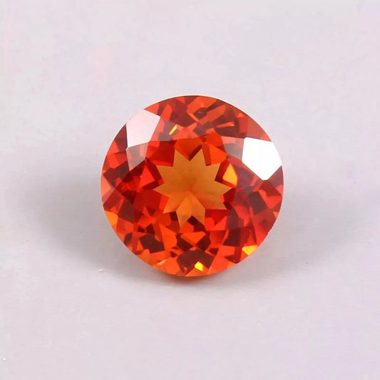Round Orange Sapphire gemstone on a light gray background