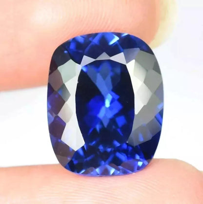 Ceylon Blue Sapphire gemstone held between two fingers against a neutral background