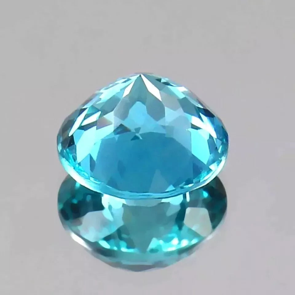 Faceted Parti Sapphire gemstone on a gray background