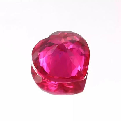 Heart-shaped pink ruby gemstone on a white background