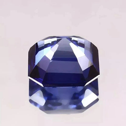 Faceted Royal Blue Sapphire gemstone on a light gray background