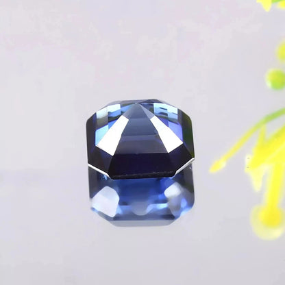 Faceted Blue Sapphire gemstone on a light gray background