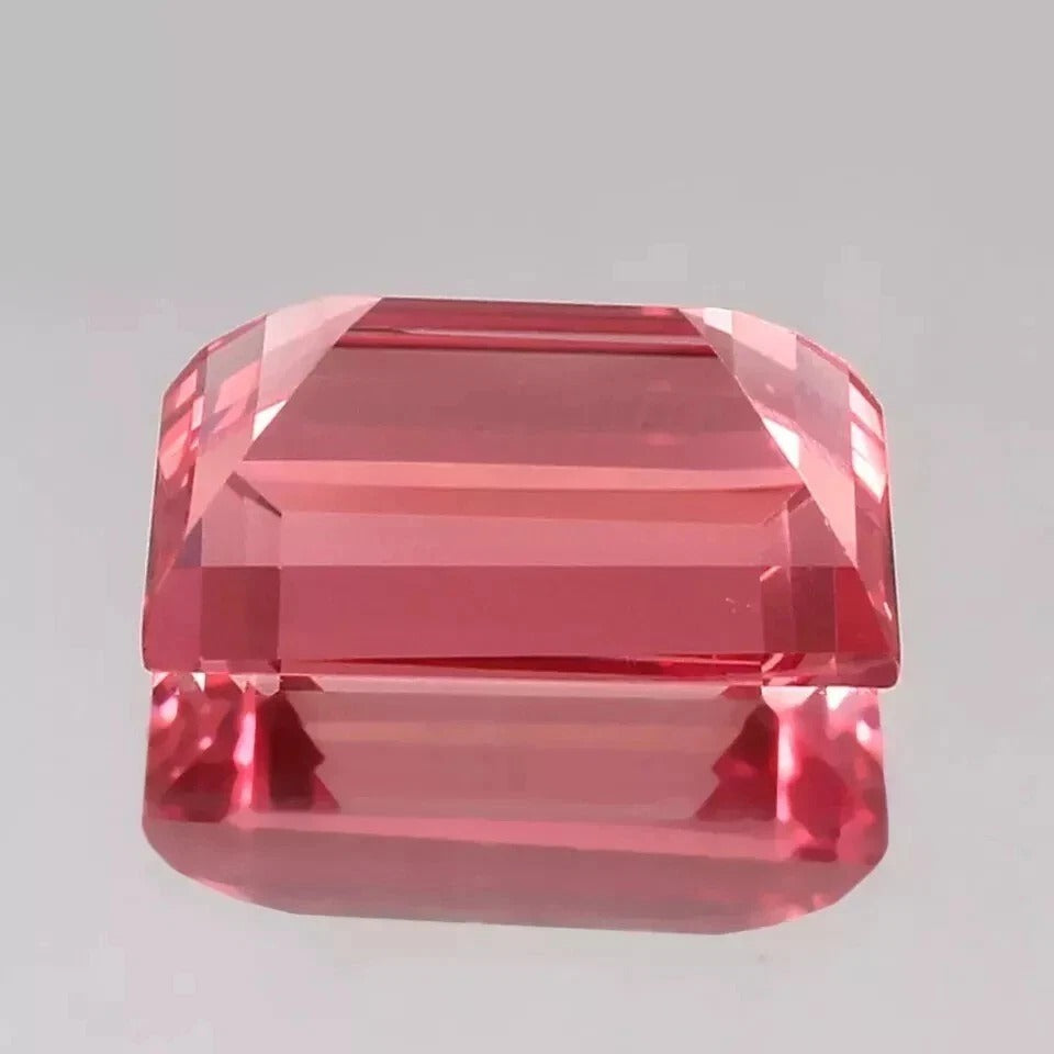 Padparadscha Sapphire – Baguette Cut gemstone on a gray background
