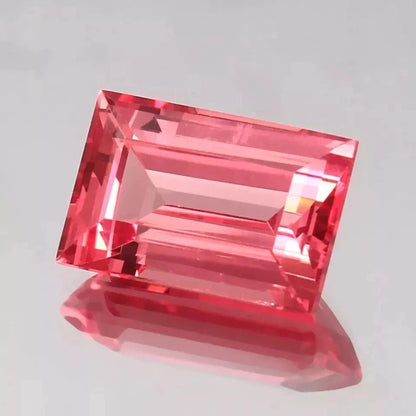 Padparadscha Sapphire – Baguette Cut gemstone on a light gray background