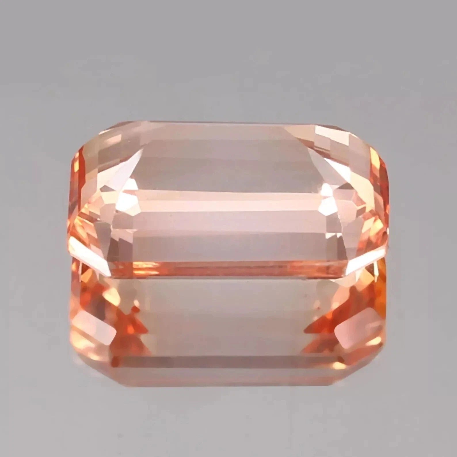 Octagonal Bi-Color Padparadscha gemstone on a gray background