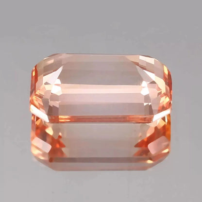 Octagonal Bi-Color Padparadscha gemstone on a gray background