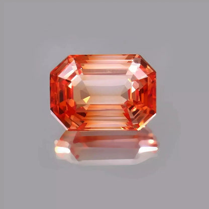Octagonal Bi-Color Unheated Padparadscha sapphire gemstone on a gray background