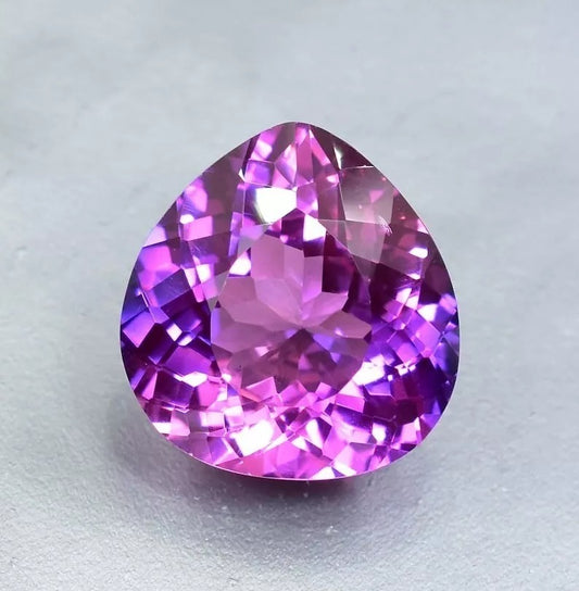 Purple Blue Sapphire gemstone on a light gray background