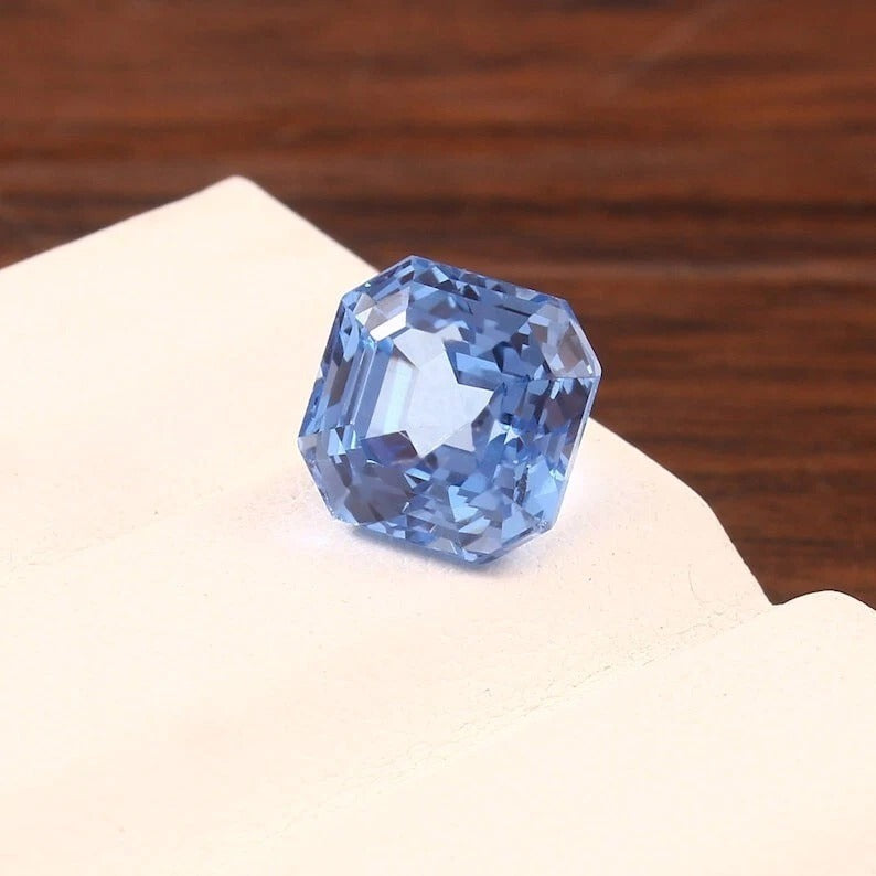Blue Spinel diamond on a wooden surface