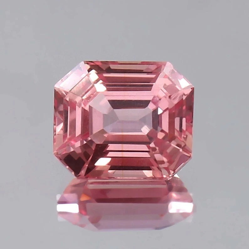 Pink Padparadscha Sapphire gemstone with a clear gray background