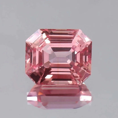 Pink Padparadscha Sapphire gemstone with a clear gray background