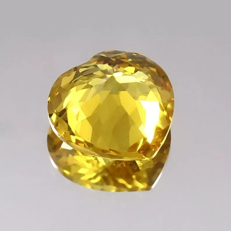 Faceted Yellow Sapphire gemstone on a gray background