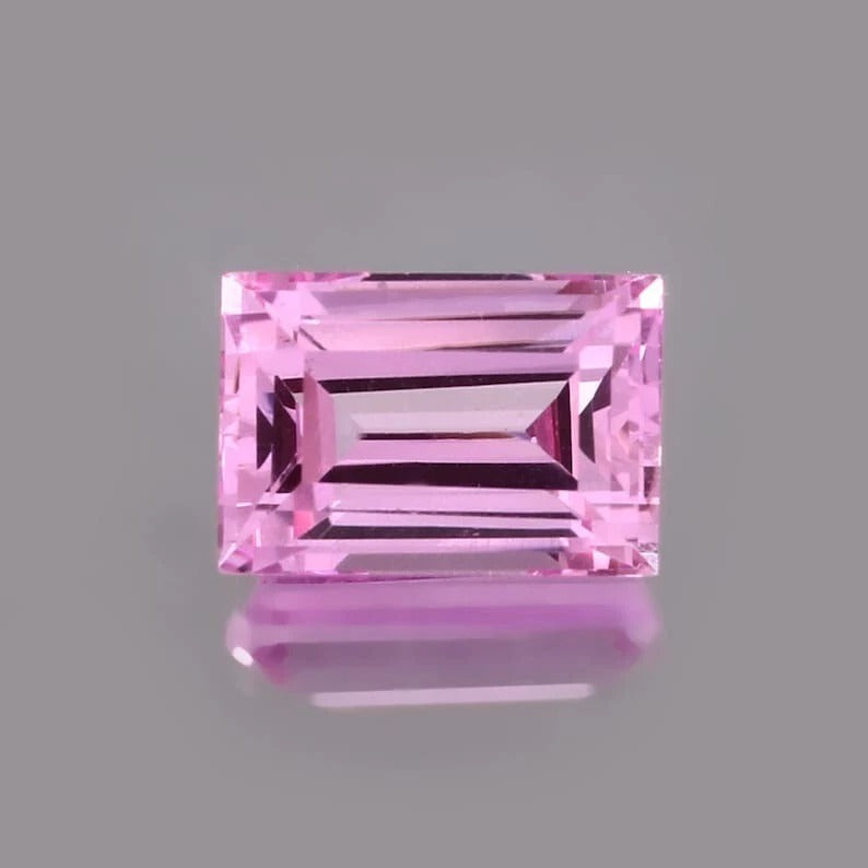 Pink Baguette Cut sapphire gemstone on a gray background