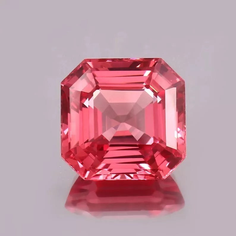 Octagonal Padparadscha Sapphire gemstone on a gray background