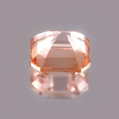 Padparadscha Sapphire – Peach Faceted gemstone on a gray background