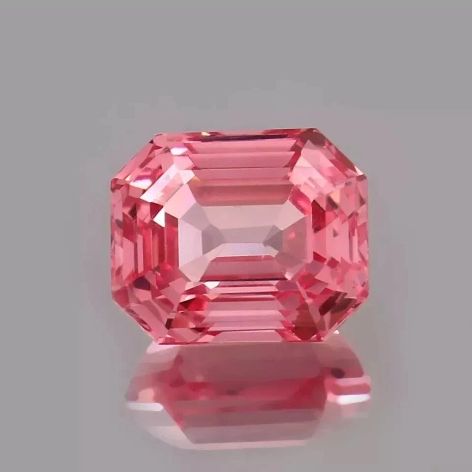 Pink Padparadscha Sapphire gemstone on a gray background