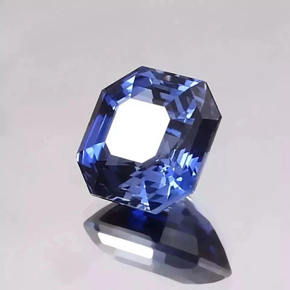 Faceted Royal Blue Sapphire gemstone on a light gray background