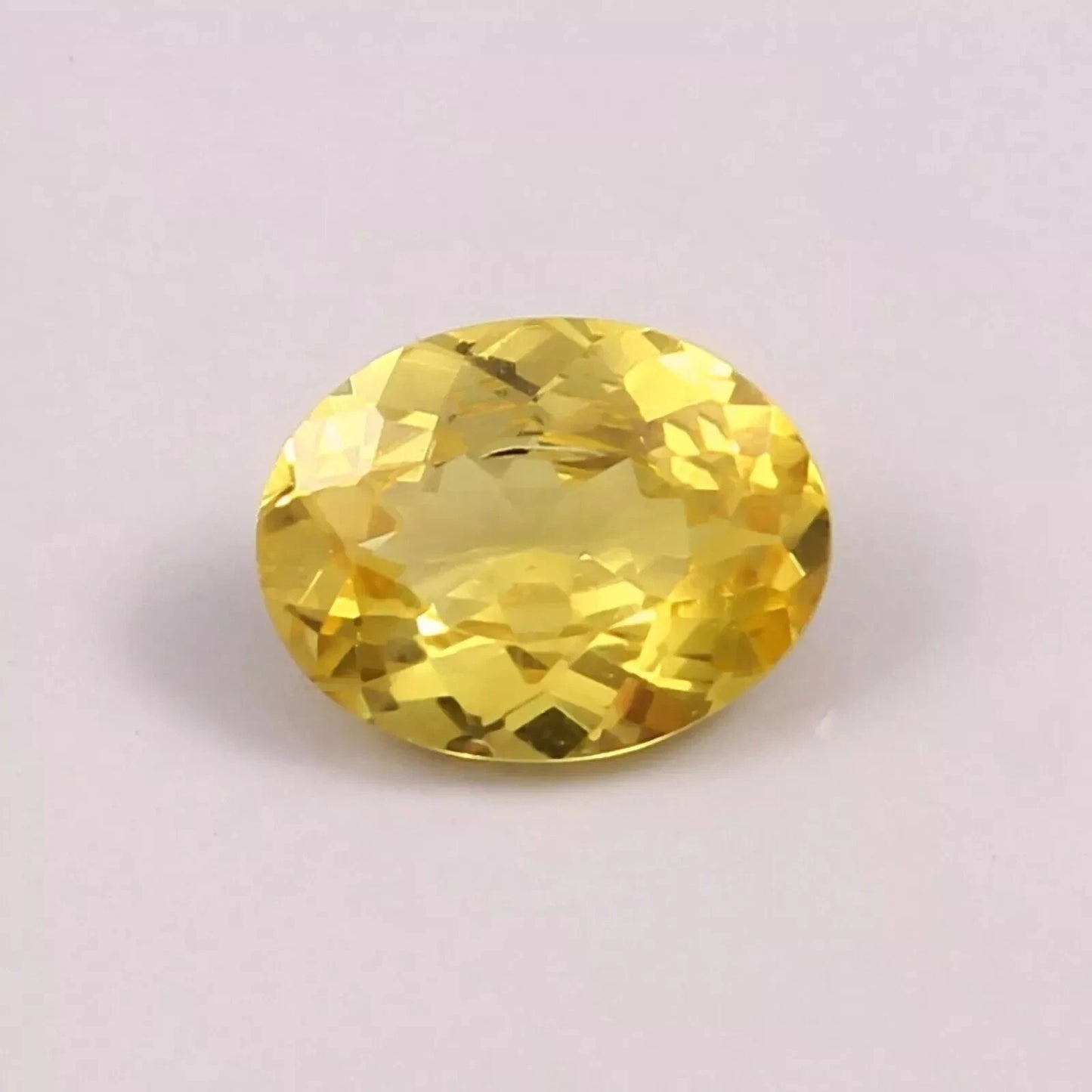Yellow Sapphire gemstone on a light purple background