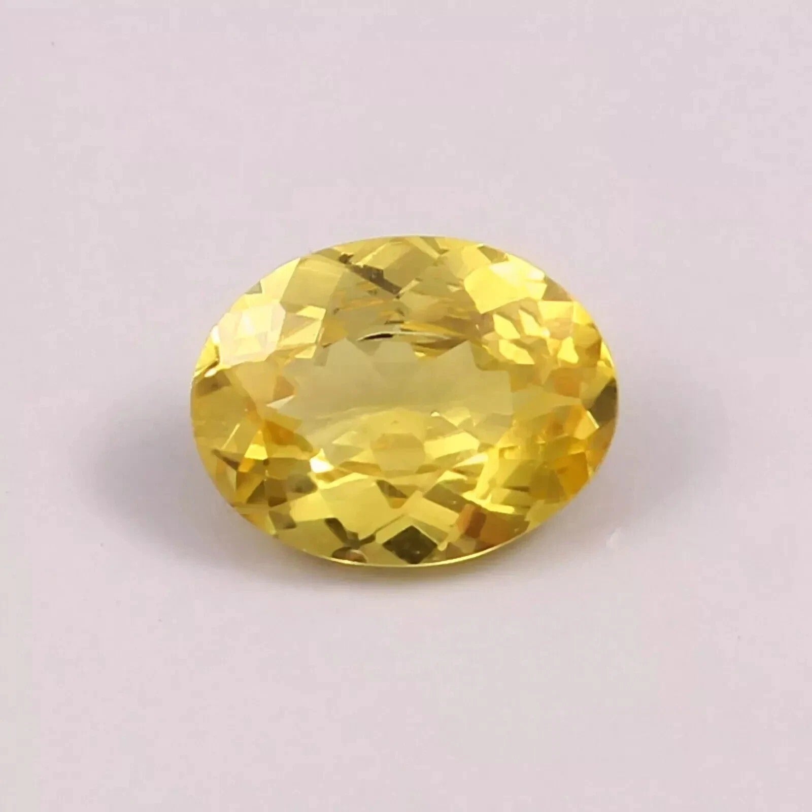 Yellow Sapphire gemstone on a light purple background