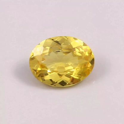 Yellow Sapphire gemstone on a light purple background