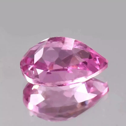 Pink Sapphire gemstone on a gray background