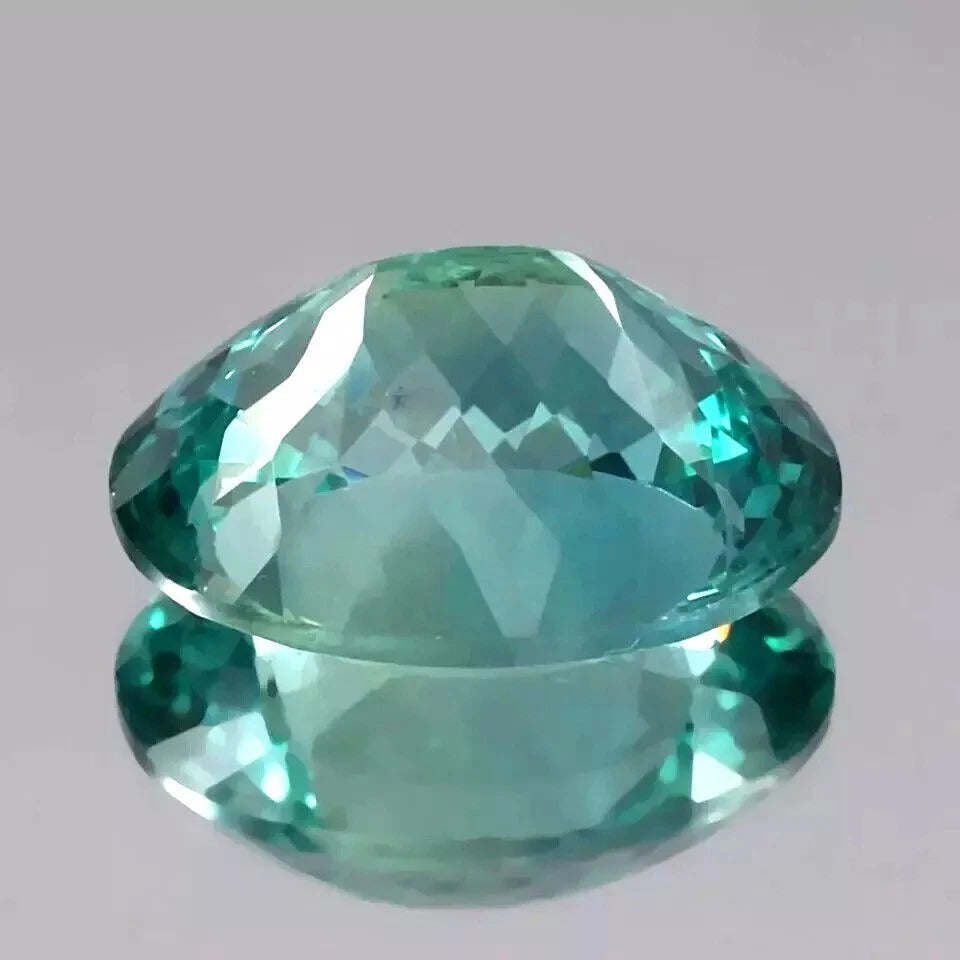 Faceted Bi-Color Parti-Sapphire  gemstone on a gray background