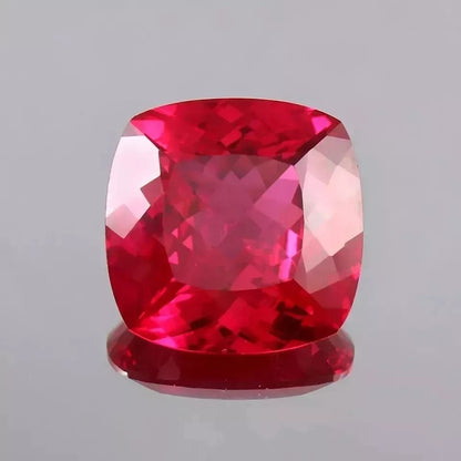 Faceted Blood Red Ruby gemstone on a gray background