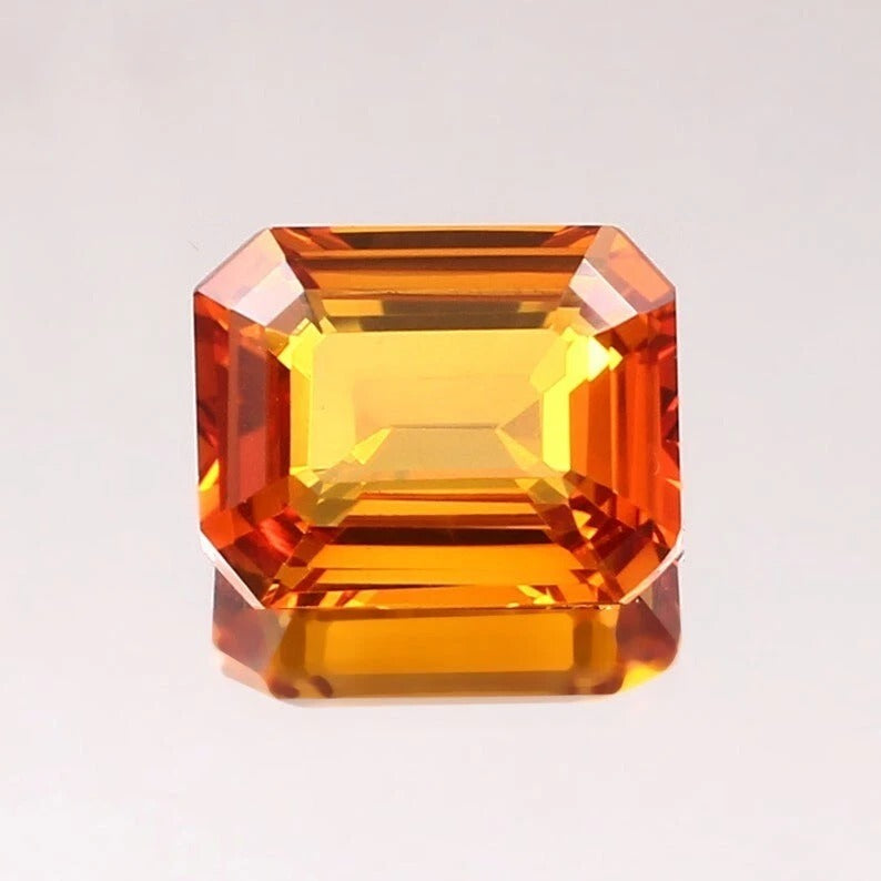 Orange Sapphire gemstone on a light gray background