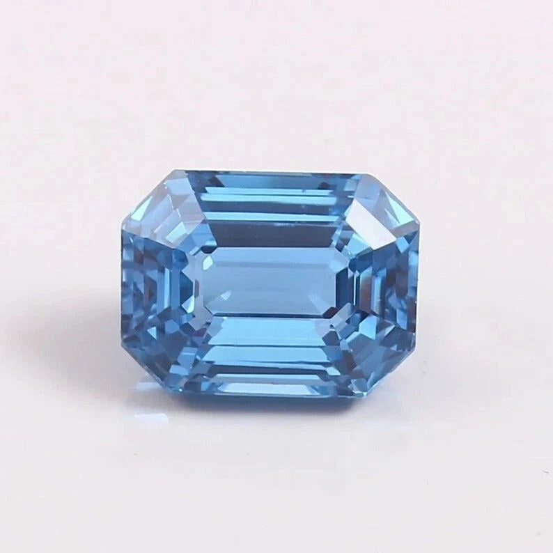 Faceted blue Aquamarine gemstone on a light gray background