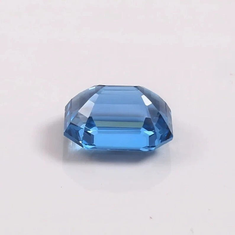 Faceted blue Aquamarine gemstone on a light gray background