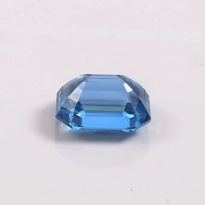Faceted blue Aquamarine gemstone on a light gray background