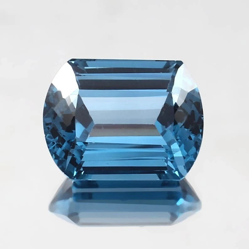 Blue Brazilian Aquamarine gemstone on a light gray background