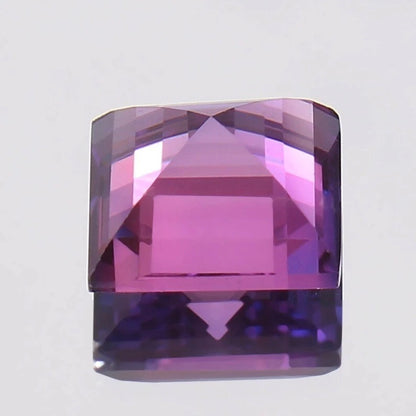 Square-cut Purple Pink Ceylon Sapphire gemstone on a light gray background