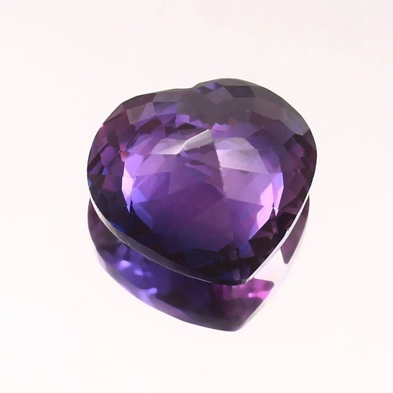 Heart-shaped Purple-Pink Sapphire gemstone on a white background